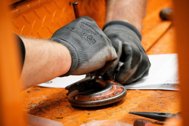 Techniker bei der Reparatur eines Lasthakens an einer Krananlage
