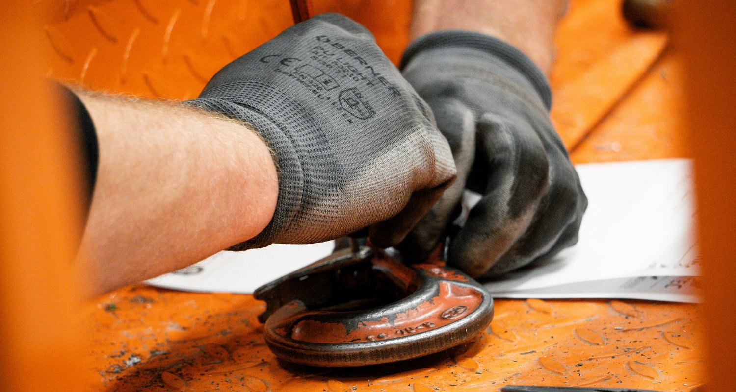 Techniker bei der Reparatur eines Lasthakens an einer Krananlage